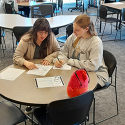 Tutor helping student at table