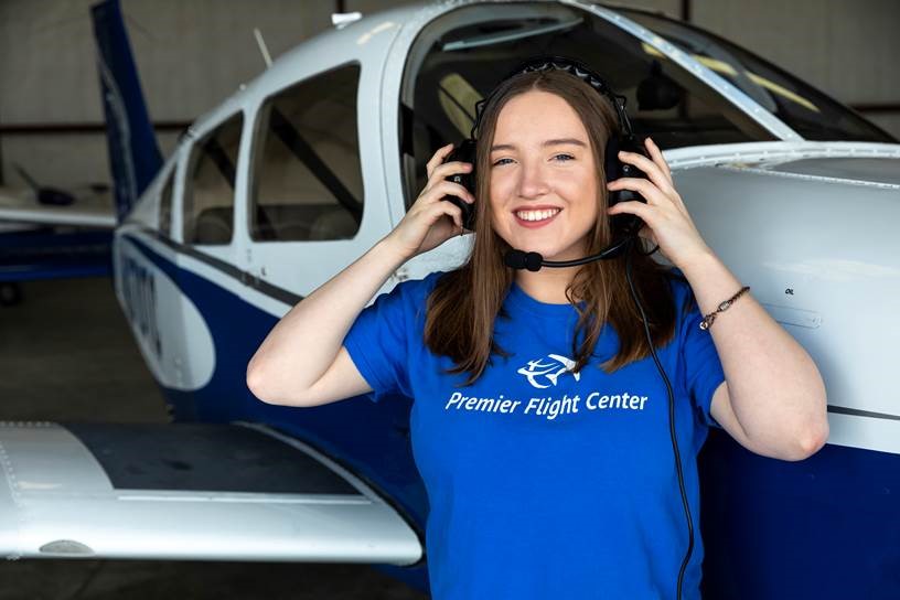 Aviation student standing by plane